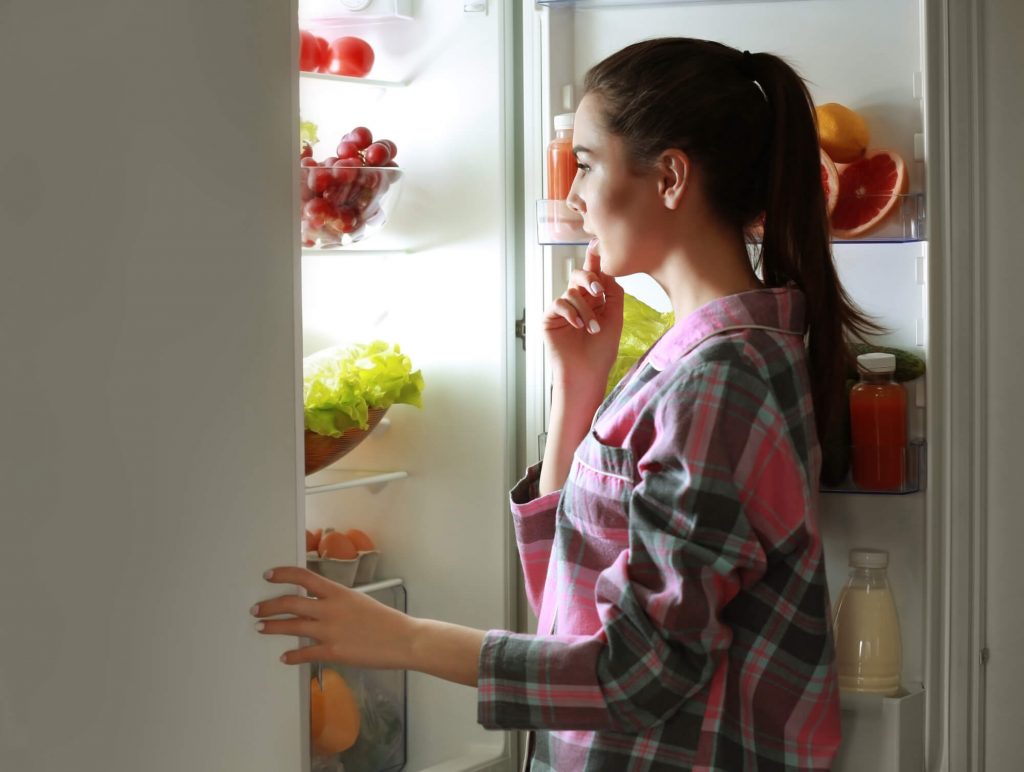mulher abrindo a geladeira